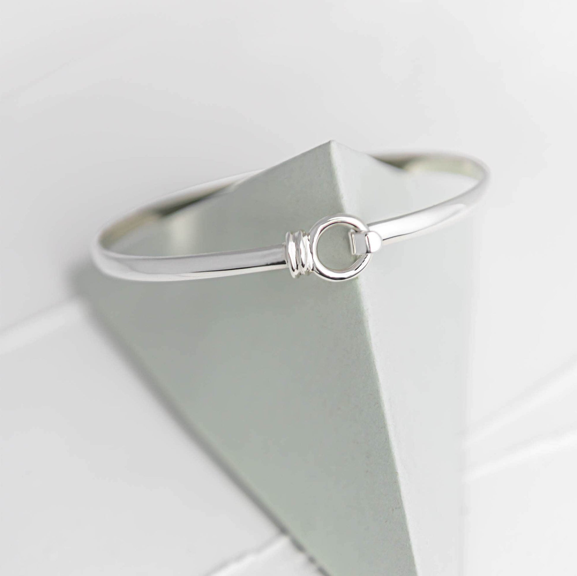 Licks silver bangle sitting on top of triangular prop