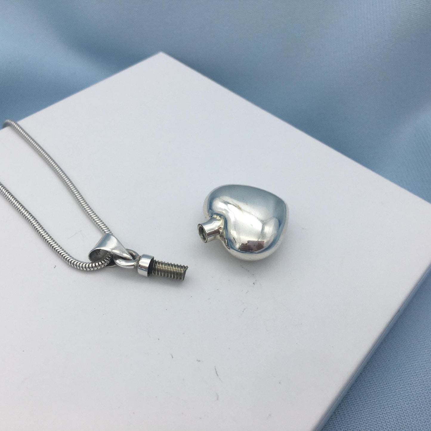silver heart urn necklace on white box