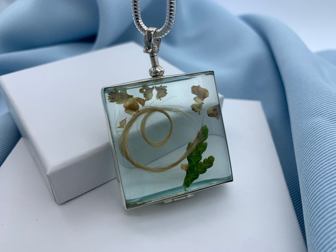 Memorial square shaped glass locket with a lock of hair inside 