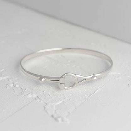 Silver bracelet on a light gray surface