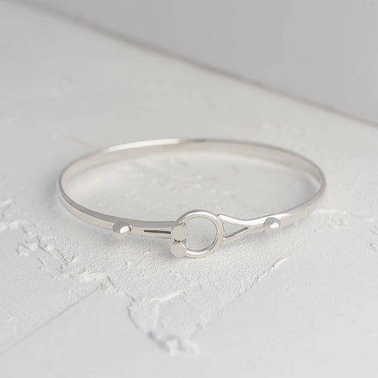 Silver bracelet on a light gray surface