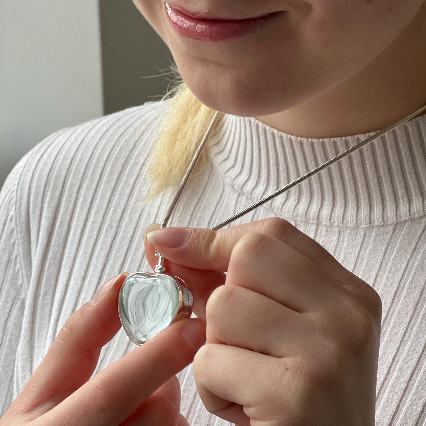 silver heart locket necklace being worn by model with blonde hair