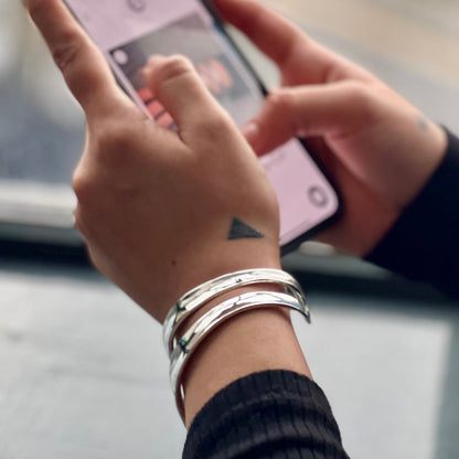 model wearing thick double stripe silver bangle while shopping online