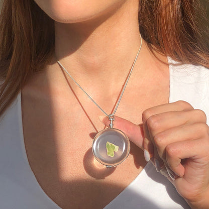 large round glass locket on a silver snake chain