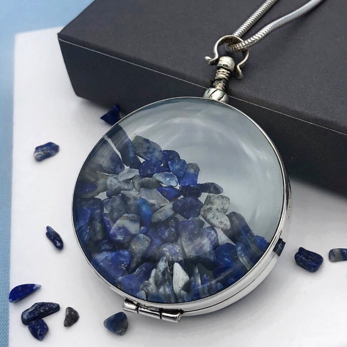 large round locket filled with blue lapis gemstones