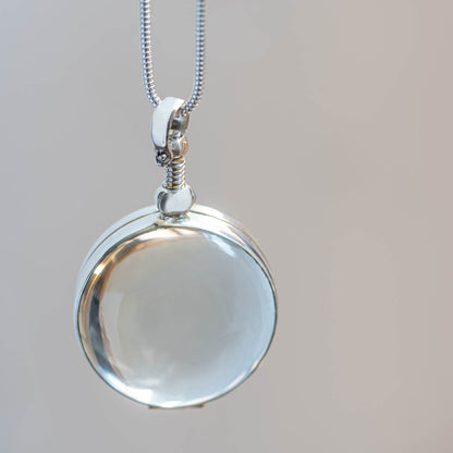 circle glass locket hanging from silver snake chain